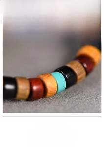 Macro shot of multi-color wooden beads and turquoise accents on a stretch bracelet