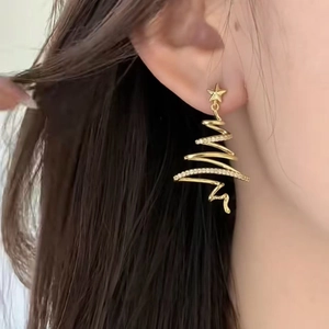 Close-up of golden hollow spiral Christmas tree earrings with star and rhinestones