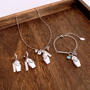 Detail of luxury zircon bear jewelry set including necklace, bracelet and earrings on wood tray