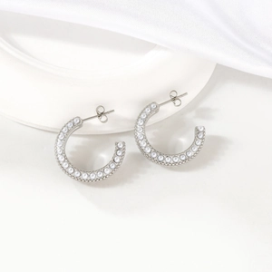 Elegant C-shaped silver stud earrings with inlaid pearls on a minimalist white background