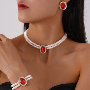 Detailed view of red gemstone and pearl jewelry set including necklace, bracelet and earrings