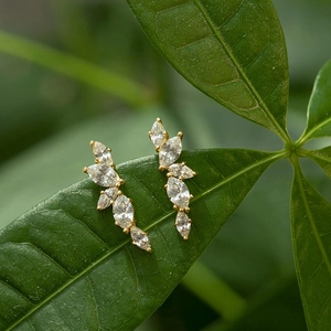 Elegant gold olive leaf stud earrings with marquise-cut cubic zirconia on green leaves