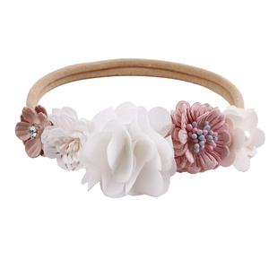 Close-up of floral baby headband with 5 fabric flowers, rhinestones, and pearls