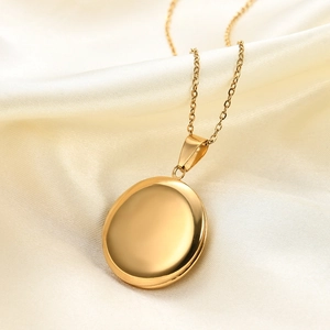 Detailed close-up of a 27mm round gold polished locket pendant on elegant satin fabric