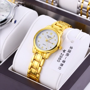 Detail of gold quartz watch with white textured dial and date display in luxury gift box