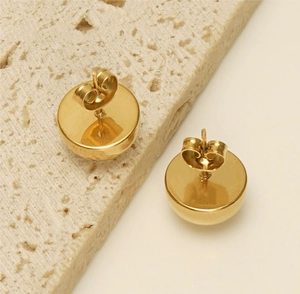 Detail of gold dome stud earrings with polished finish and butterfly back closure