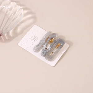 Détails de trois pinces à cheveux en résine marbrée grise avec base en métal doré