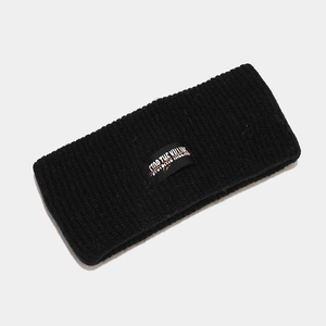 Macro detail of black knitted sports headband featuring STOP THE KILLING letter patch