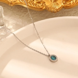 Collier en argent avec pendentif ovale en pierre bleue et halo de cristaux sur assiette