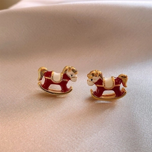 Détail de boucles d'oreilles cheval à bascule émail rouge sur satin beige doré