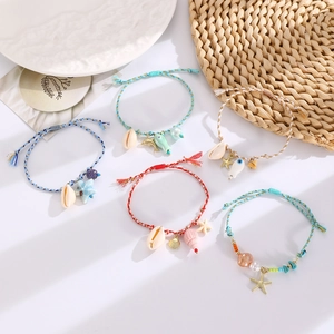 Detail of bohemian woven rope bracelets with starfish, seashell, and ceramic fish charms