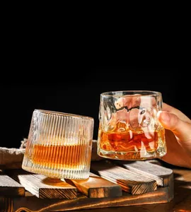 Detail of thickened whiskey glasses with vertical and wave textures on a wooden base