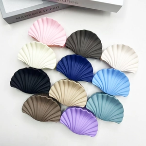 Flat lay of stylish marble texture fan-shaped hair claws in multiple colors on white background