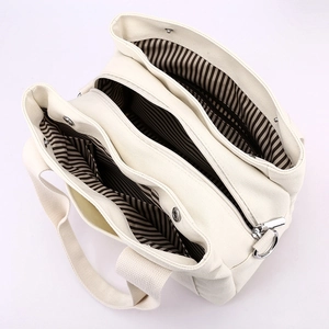 Cream canvas tote bag for women with multi-compartment interior and striped lining