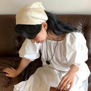 Foulard tricoté crème rétro et robe à manches bouffantes blanche portés par le mannequin