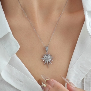 Elegant silver eight-pointed star pendant necklace with zircons on white shirt