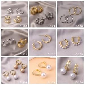 Macro display of nine luxury gold and silver earrings featuring pearls and zircons