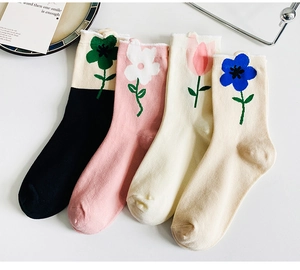 Detail of four pairs of floral cotton mid-calf socks in black, pink, yellow and beige