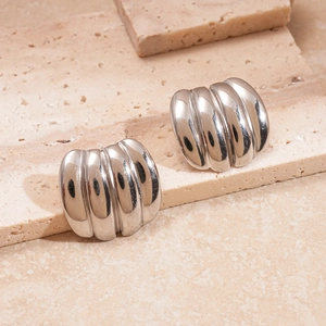Detail view of silver pleated earrings with polished geometric rib structure on stone base