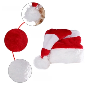 Detail of plush Christmas hat featuring soft white pompom and thick velvet red stripes