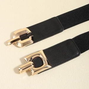 Women's black elastic waist belt with vintage gold interlocking metal buckle and leather ends