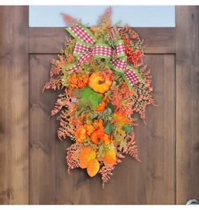 Detail of autumn wreath with pumpkins and berries on wooden door for Thanksgiving decoration