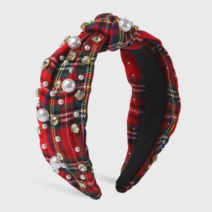 Detailed close-up of red plaid headband with knotted top, white pearls and shiny crystals