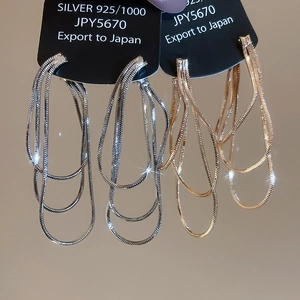 Gros plan de boucles d'oreilles à pampilles en maille serpent argentées et dorées