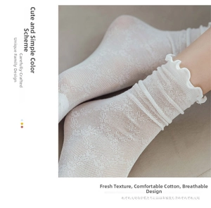 Close-up of white lace mesh socks featuring frilly lettuce edge and floral patterns