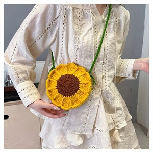 Detail of hand-knitted sunflower shoulder bag with green strap in yellow and brown