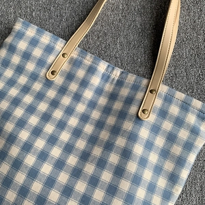 Detailaufnahme der blau-weißen Canvas-Tasche mit verstärkten Riemen aus Kunstleder