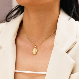 Vintage oval cat-eye stone pendant necklace with gold chain worn on a neck