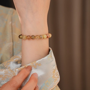 Détail du bracelet en cristal de quartz rutilé naturel sur le poignet d'un modèle