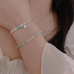 Silver bead bracelet with colorful gemstones and pearls worn on a woman wrist