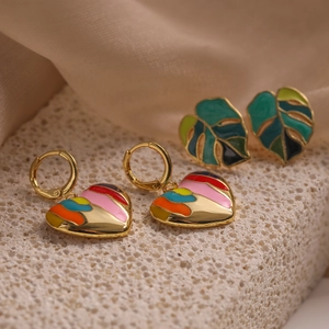Gold-plated enamel heart and leaf earrings set displayed on a textured stone base