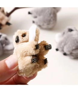 Close-up of the beige plush koala hair clip showing soft texture and back clip detail