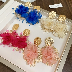 Detail view of large chiffon flower petal earrings in blue, cream, rose and light pink colors