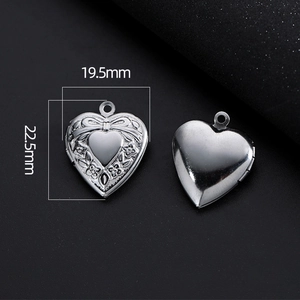 Detail of silver heart locket with bow and flower engravings and dimension markings
