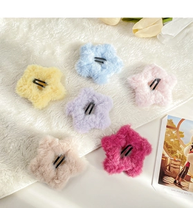 Detail of colorful plush star hair clips on a soft white faux fur background with tulips