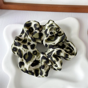Detailed view of French vintage leopard print hair scrunchie with soft satin fabric texture