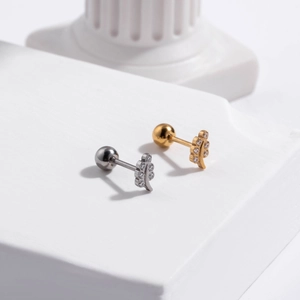 Close-up of gold and silver leaf cartilage studs with cubic zirconia on stone base