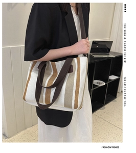 Detail view of striped canvas tote bag showing textured fabric and wide shoulder strap