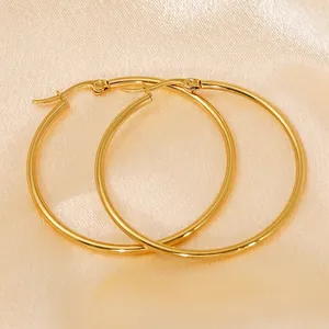 Minimalist 18K gold plated stainless steel hoop earrings on champagne silk background