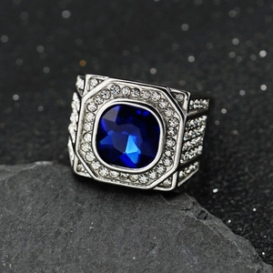 Macro detail of men's silver steel signet ring with blue gemstone and pavé diamonds