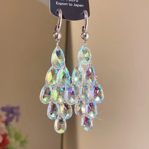 Détail macro de boucles d'oreilles à pompons longs avec cristaux AB en forme de goutte