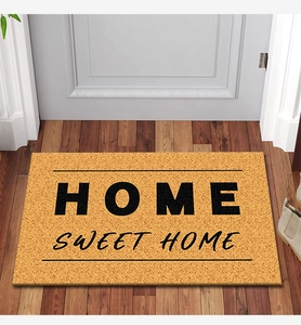 Detailed texture of Home Sweet Home coconut fiber doormat on a natural wooden floor