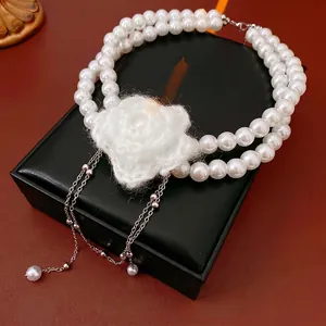 Elegant double-layered pearl necklace with white knitted flower and silver tassels