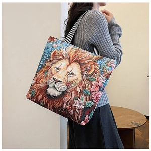 Detailed embroidery of a lion head and floral patterns on a canvas tote bag