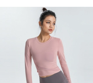Détail de l'ourlet croisé sur un haut de yoga à manches longues rose poudré ajusté