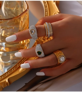 Close-up of luxury gold-plated rings with crystals and freshwater pearl on hand